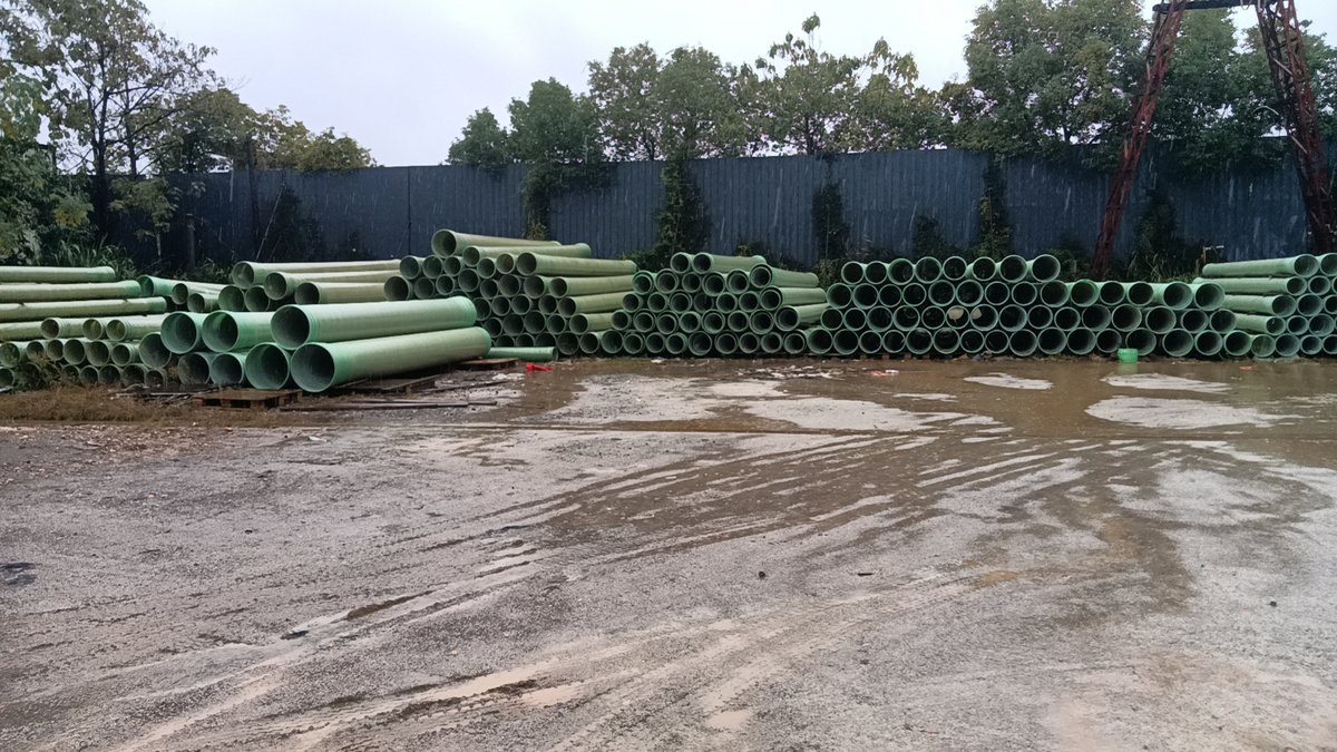 成品库区大量绿色玻璃钢管道整齐堆放待发货