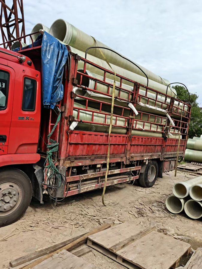 发货现场全景：吊车、待装货车、成品管堆场